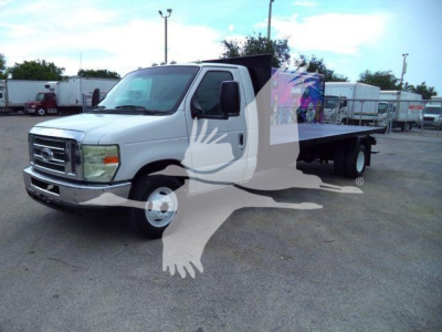 Flatbed tow truck 2011 Ford E450 in a used inventory lot, white cab and flatbed visible, stock # T07531FM.