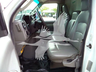 Truck cabin interior of a 2011 Ford E450, front seats and dashboard visible from the open door, gray cloth seats and steering wheel.