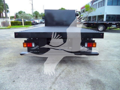 Rear view of a flatbed truck bed on a Ford E-450, taillights visible, metal platform and bumper.
