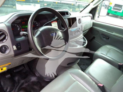 Ford E-450 truck interior showing steering wheel, dashboard, and front seats with radio/navigation screen.
