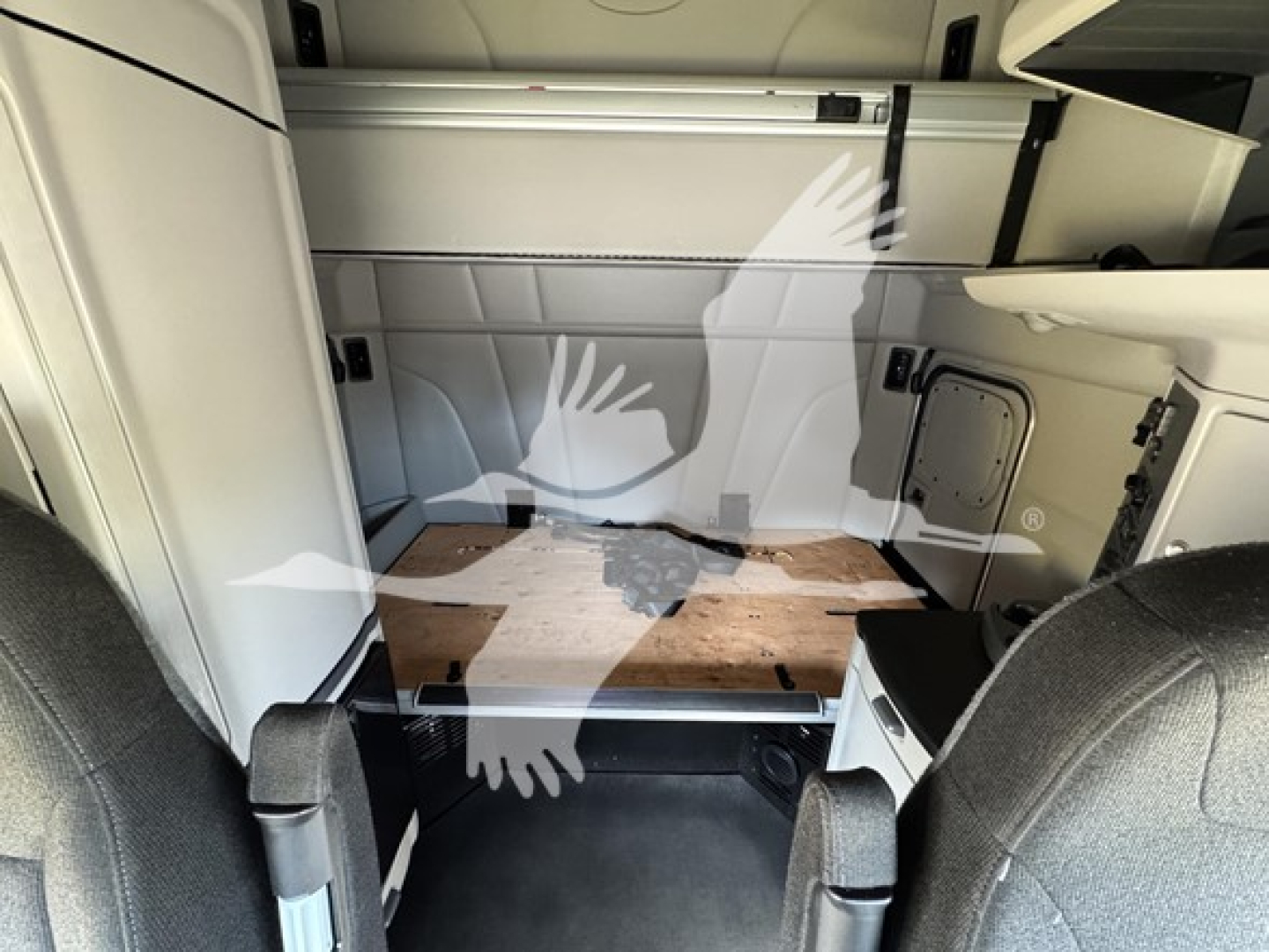 Peterbilt 579 interior sleeper area with side storage and cargo platform, visible cabin walls and seating front seats in foreground.