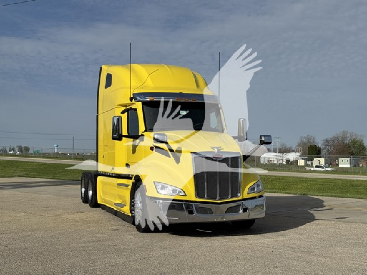 Peterbilt 579 truck in yellow paint, front view showing cab, grille, and headlights.