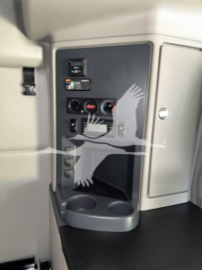 Peterbilt 579 cab interior showing dashboard controls and cup holders in lower console, with switch panels and gauges visible.