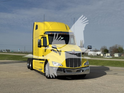 Peterbilt 579 truck in yellow paint, front view showing cab, grille, and headlights.