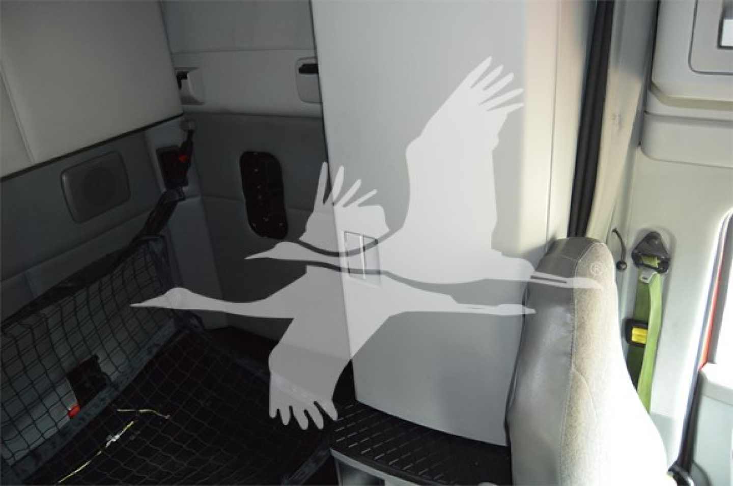 Kenworth T680 cab interior view with seating area and entry, reflective watermark overlaid.