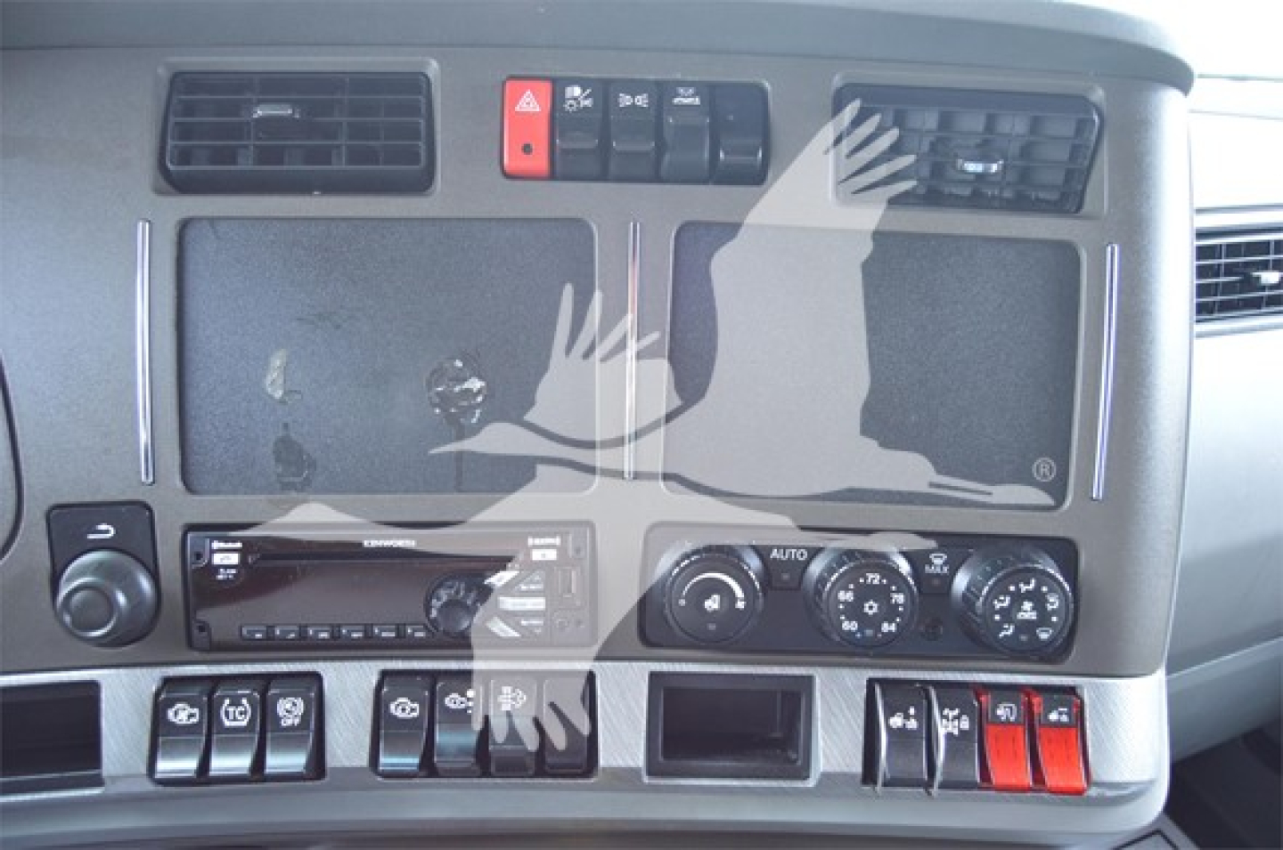 Dashboard of a Kenworth truck showing control switches and climate controls with labels; no legible part numbers visible.