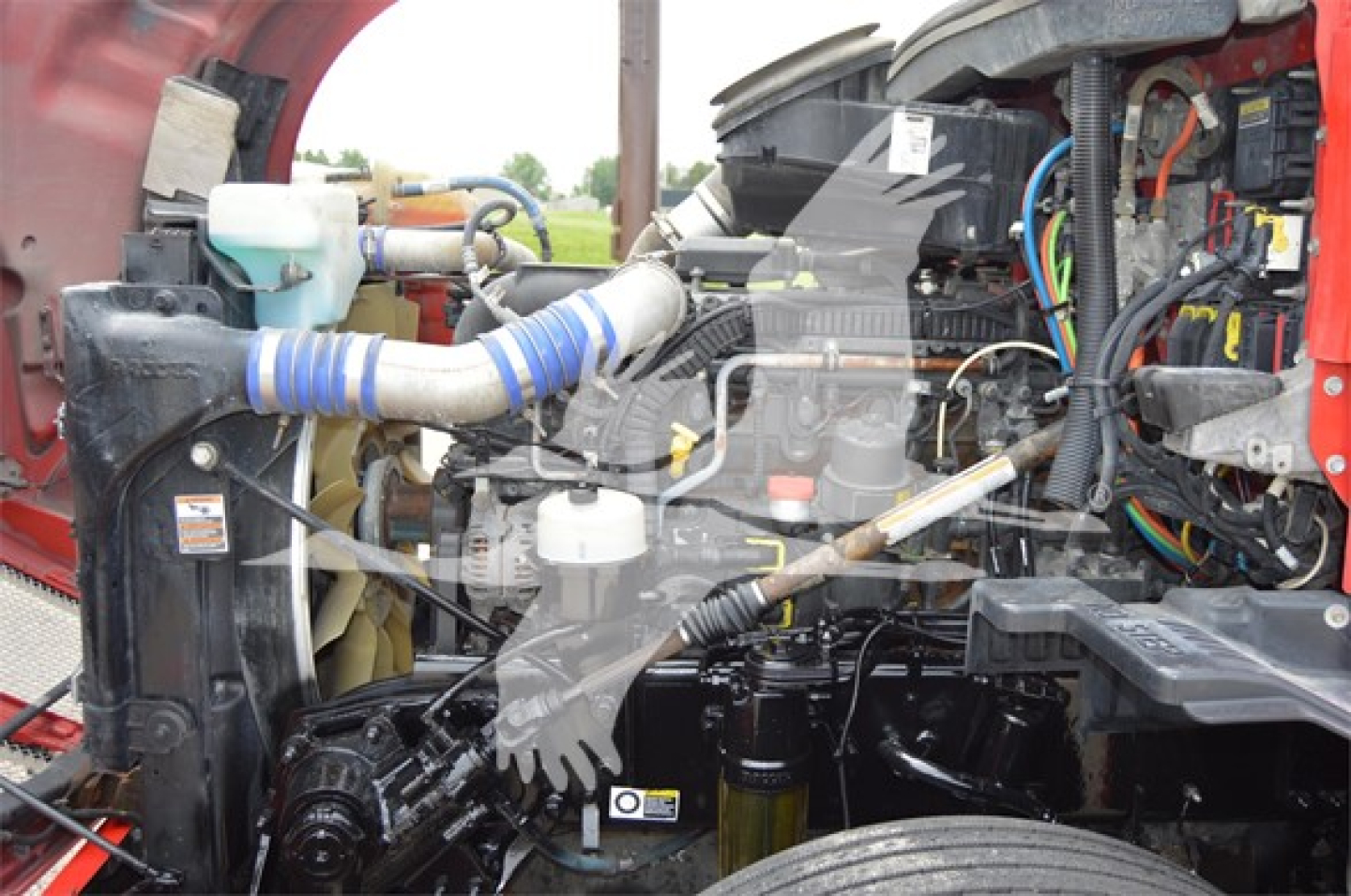 Kenworth T680 engine bay showing coolant reservoir, intercooler hoses, and engine components in view.