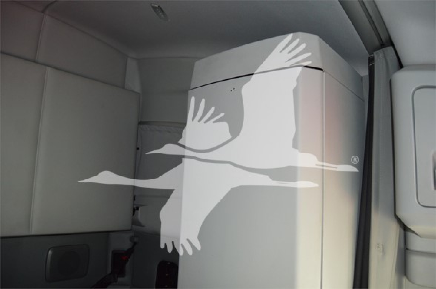 Kenworth T680 cab interior view with sleeper area and vertical storage cabinet.