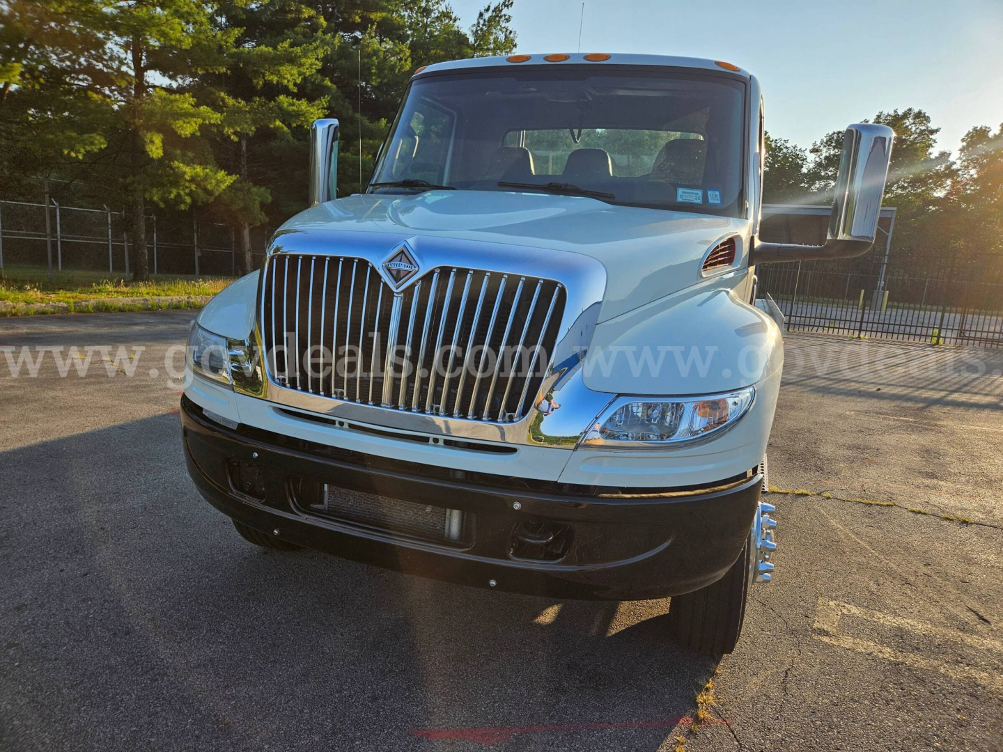 Front view of a white 2019 International MV607 tow truck showing large chrome grille, dual mirrors, and front bumper.