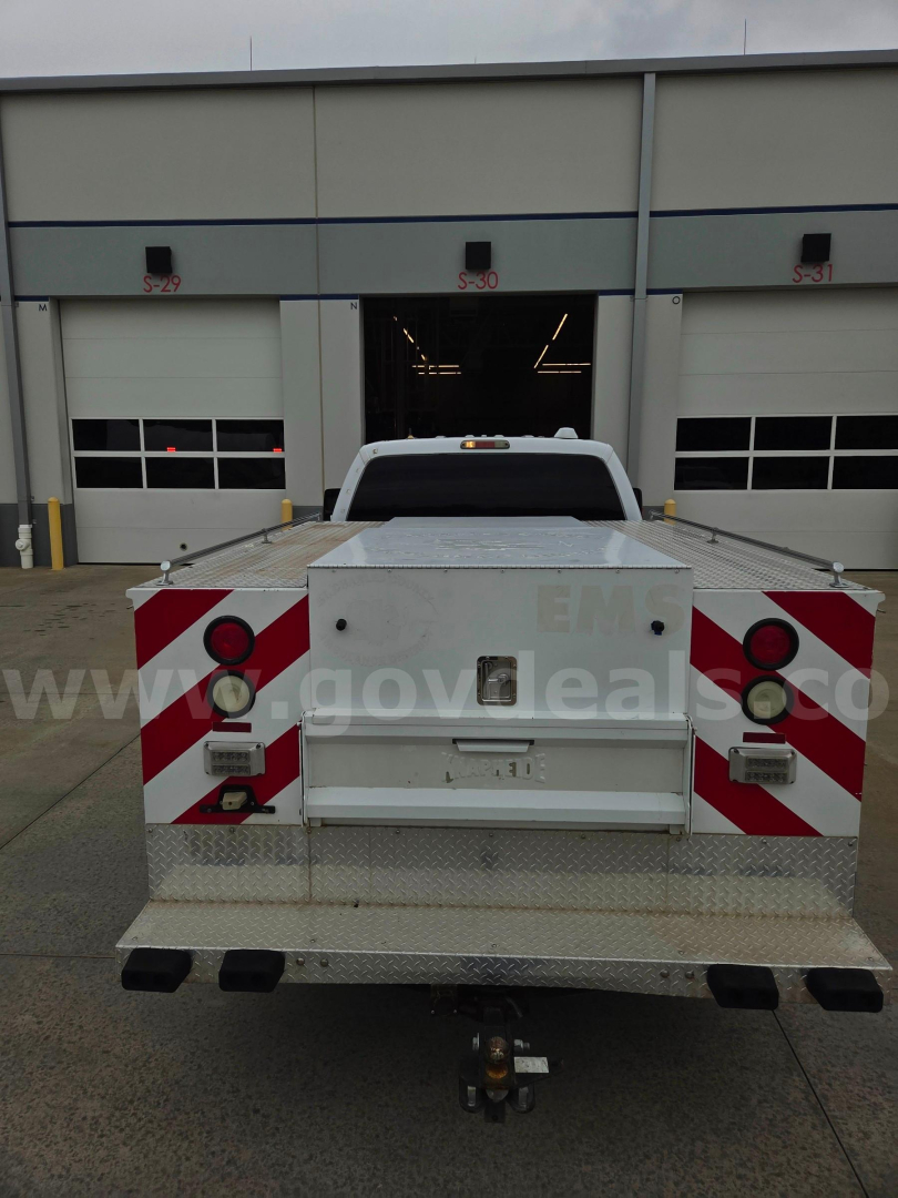 Truck bed apparatus on a Ford F-250 service truck with reflective red-and-white chevron panels on the rear, taillights, and a hitch receiver.