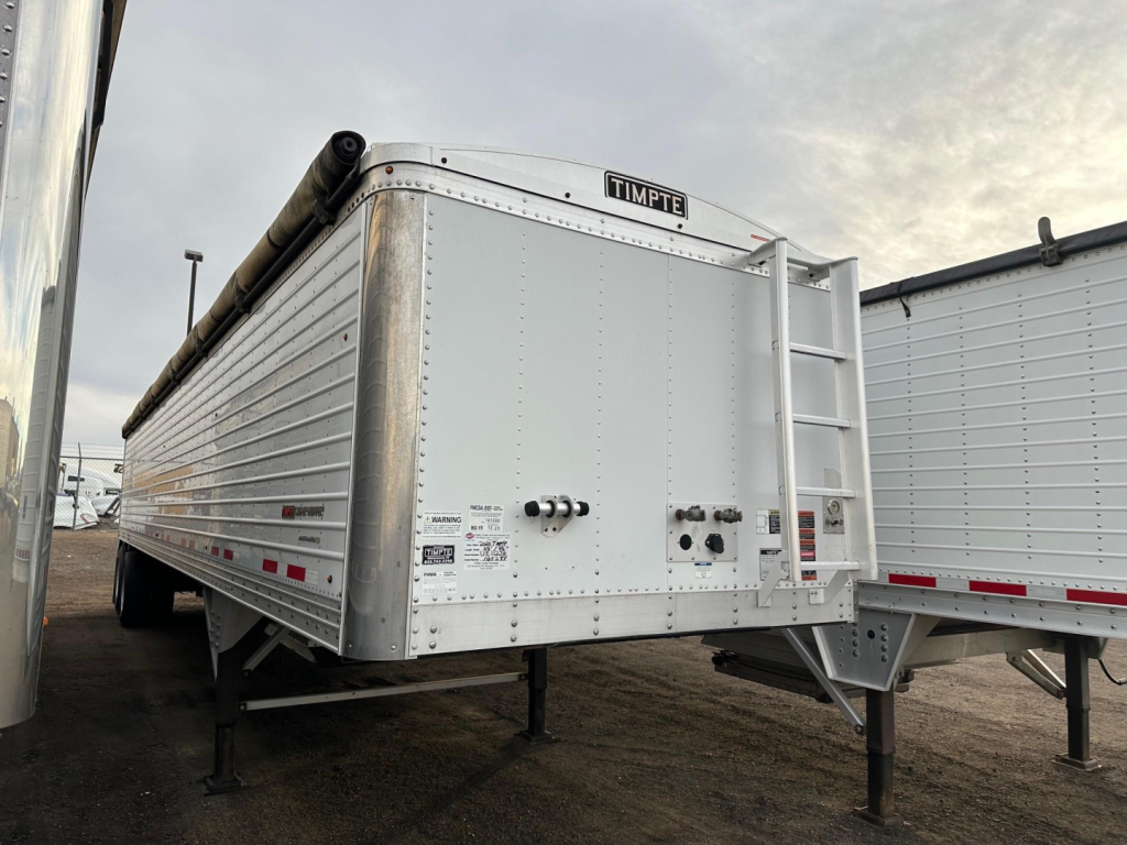Timpte Super Hopper trailer showing side and rear with ladder, tongue jack, and rear discharge area.