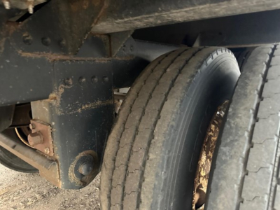 Trailer axle and dual tires on a 2020 Timpte Super Hopper showing wheel, suspension mount, and frame with dirt and rust-free surface.
