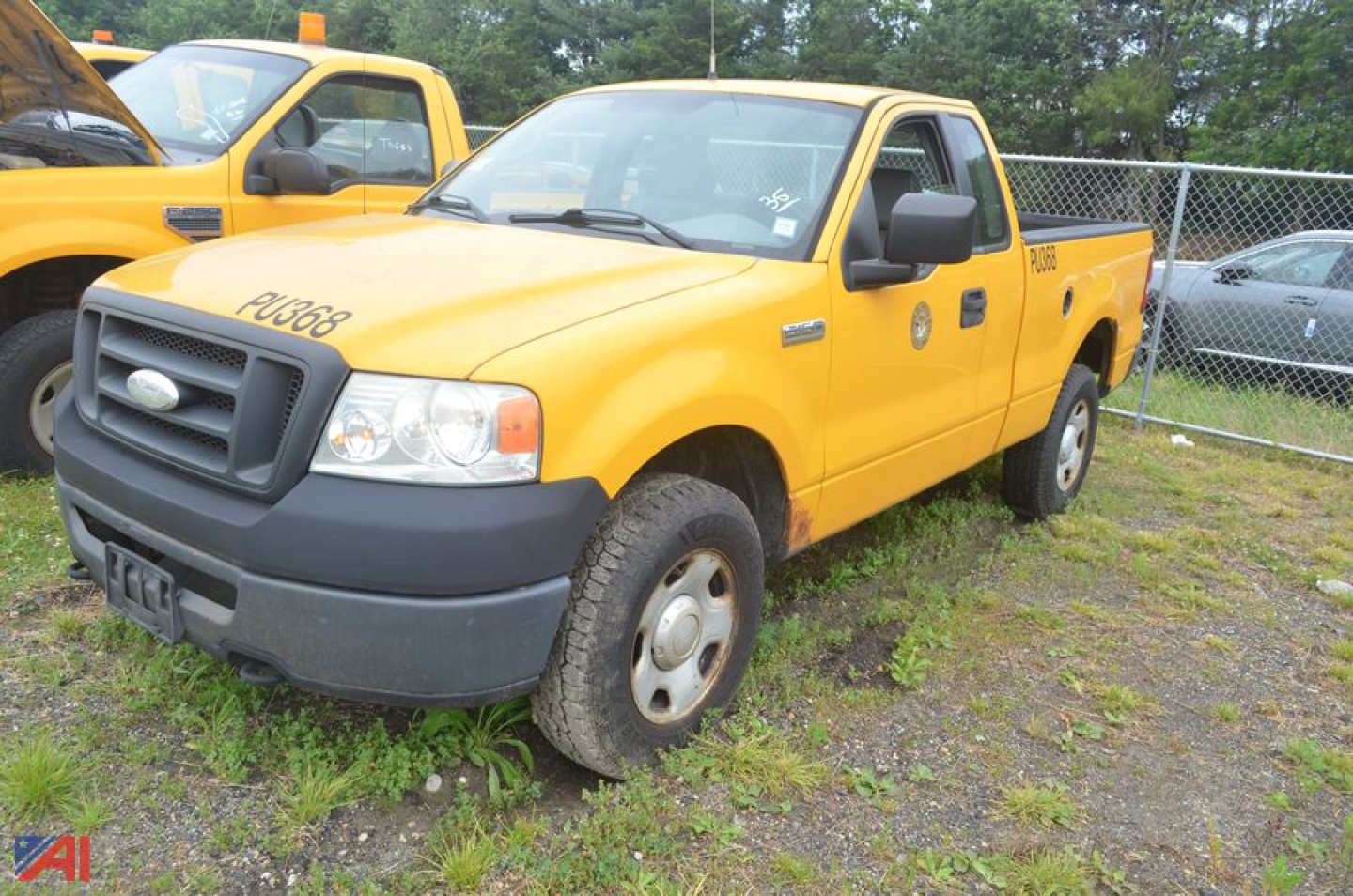 Ford F-150 pickup truck in yellow with extended cab, front grille and bumper visible, parked in a lot.