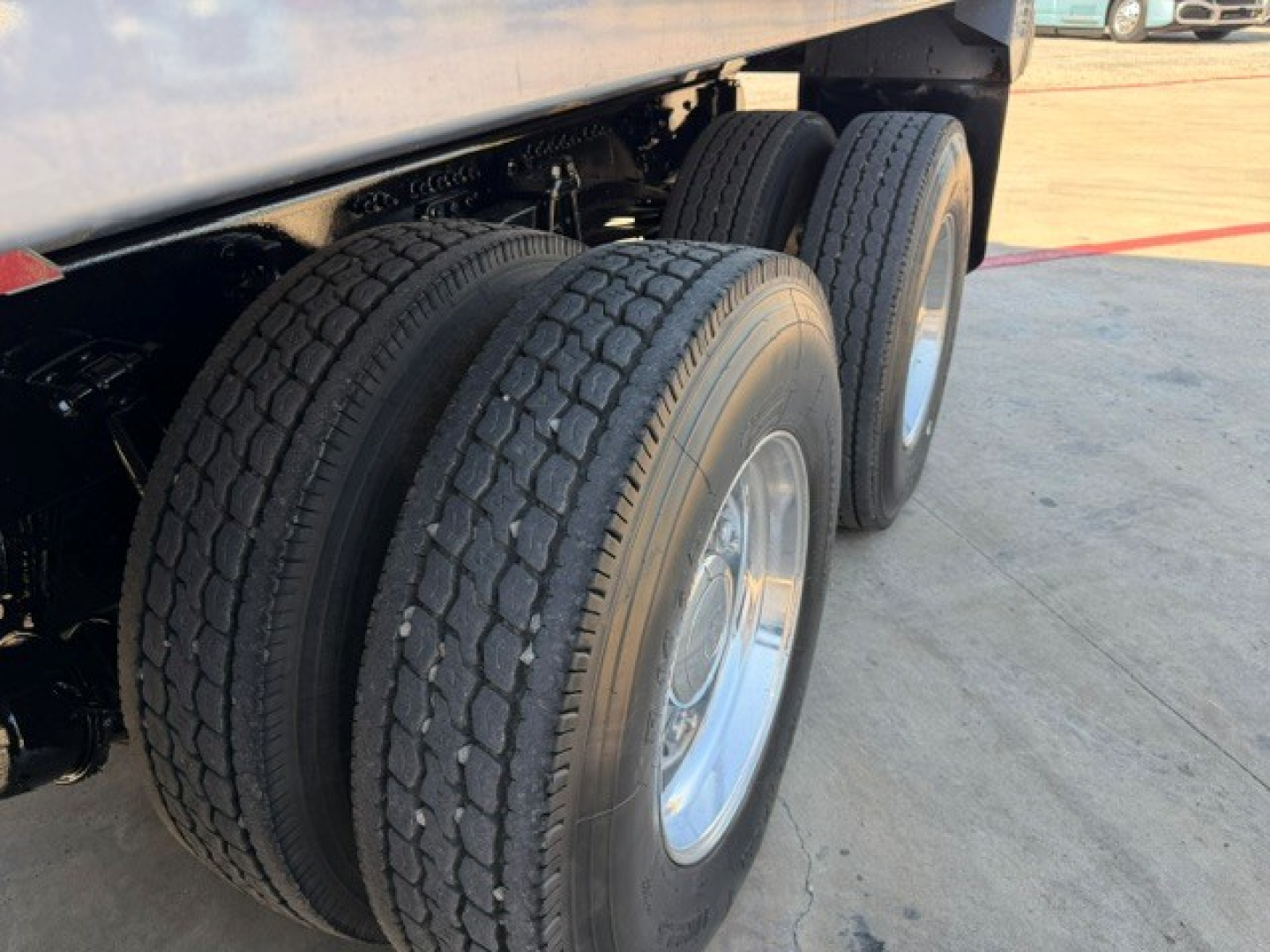 Triple rear tires of a Volvo dump truck chassis with visible twin-axle wheels and tire treads.