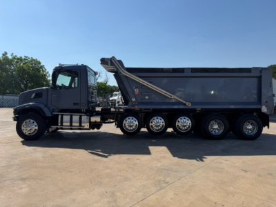 Volvo dump truck side view showing multiple wheels, dump bed, and hydraulic hoist.