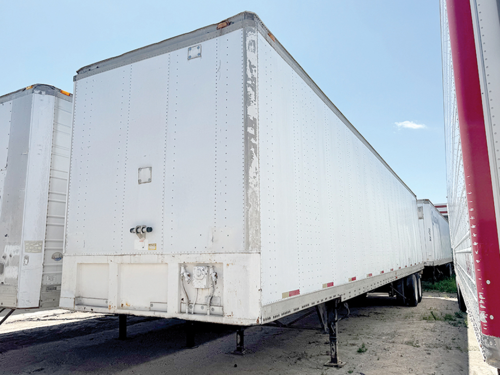 Trailer: aluminum Hobbs van trailer with legs extended and side riveted panels.