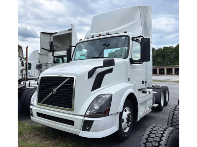 Volvo VNL 300 daycab tractor in white, front-left angle showing grille, headlights, and side mirrors.