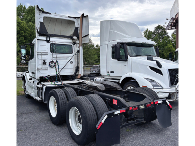 Volvo VNL 300 semi truck tractor rear view showing fifth-wheel and dual rear axles, white cab, sleeper in background, chassis with black components and tires.