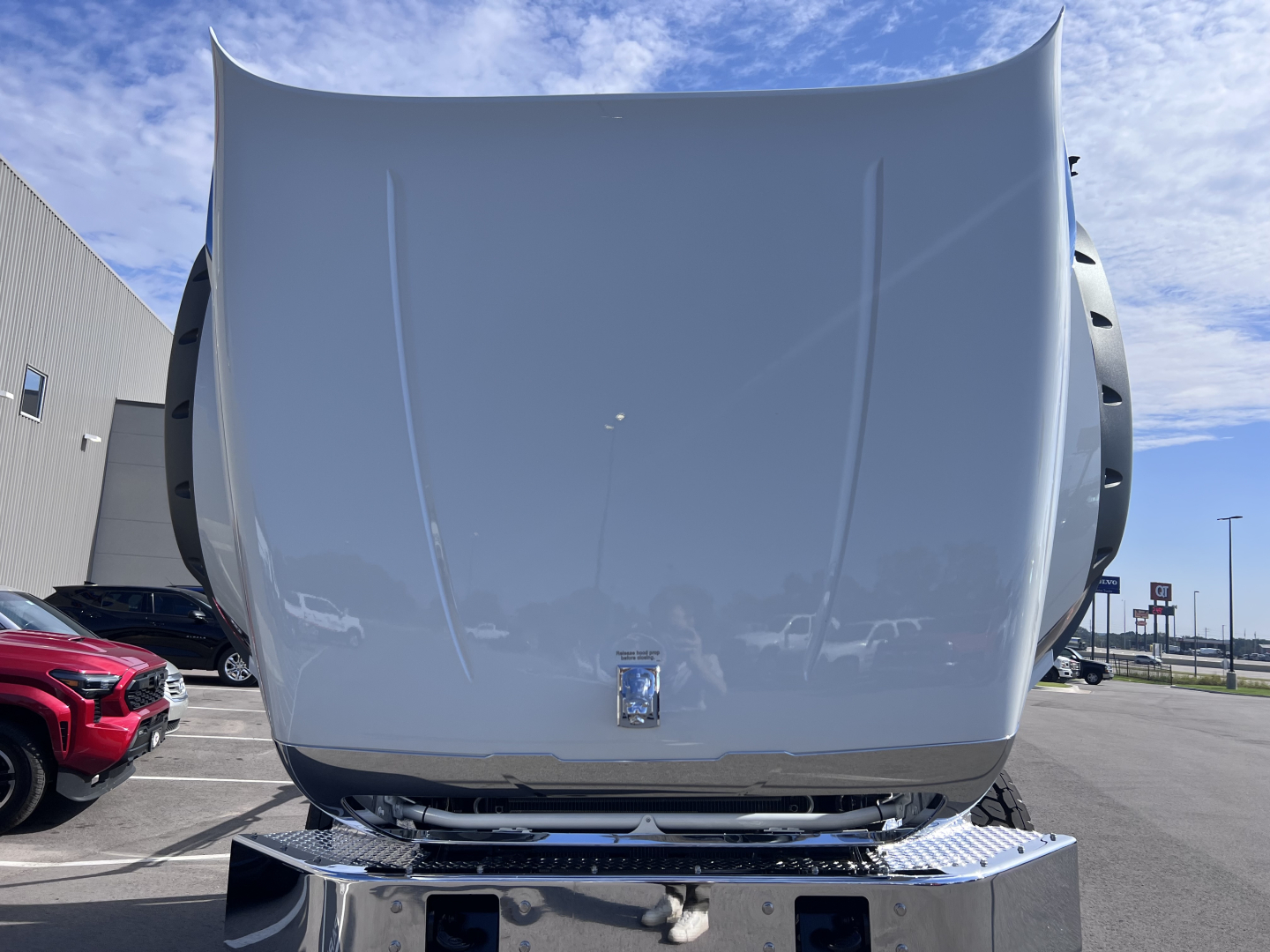 Front view of a 2026 Mack GR64B rolloff truck hood showing clean metal surface and grille area with badge.