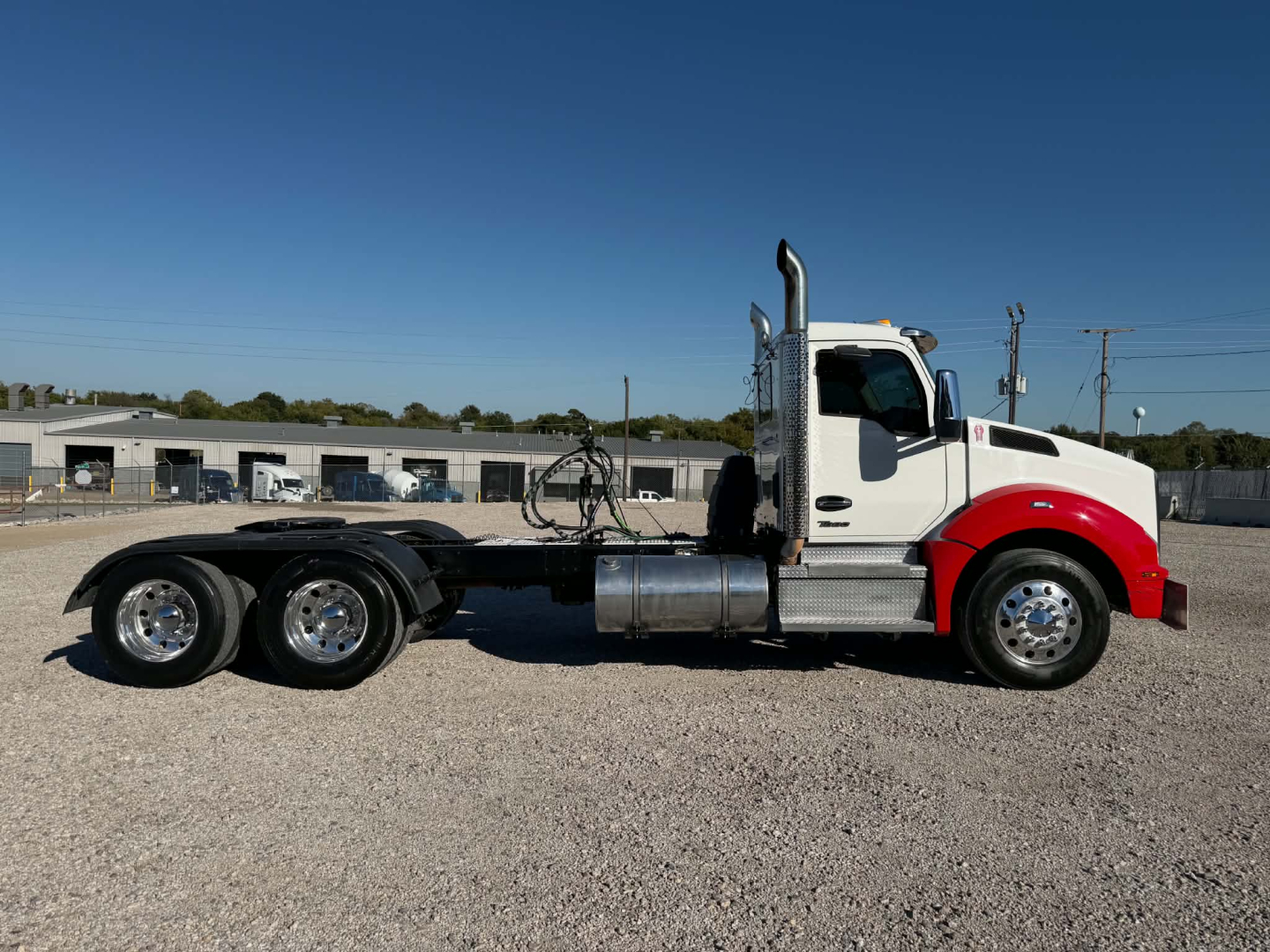 Kenworth T880 Conventional Daycab truck side view, white cab with red fenders, dual rear axles, exhaust stack, fuel tank, no visible branding text.