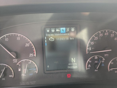 Truck instrument cluster display showing Engine Maintenance with 11243:18 hrs, N gear, economy mode, in-dashboard screen flanked by RPM and speed gauges.
