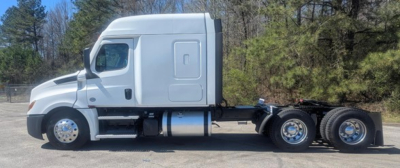 Truck side view showing Freightliner Cascadia 126 sleeper tractor with white cab and chassis, three axles at rear, fuel tank visible.