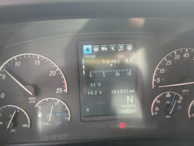 Dashboard cluster of a Freightliner Cascadia showing digital display with tires and gauges, reading Trip mpg 8.3, 91°F, 14.2 V, 363,835 mi, N economy, mph, and RPM gauge on left.
