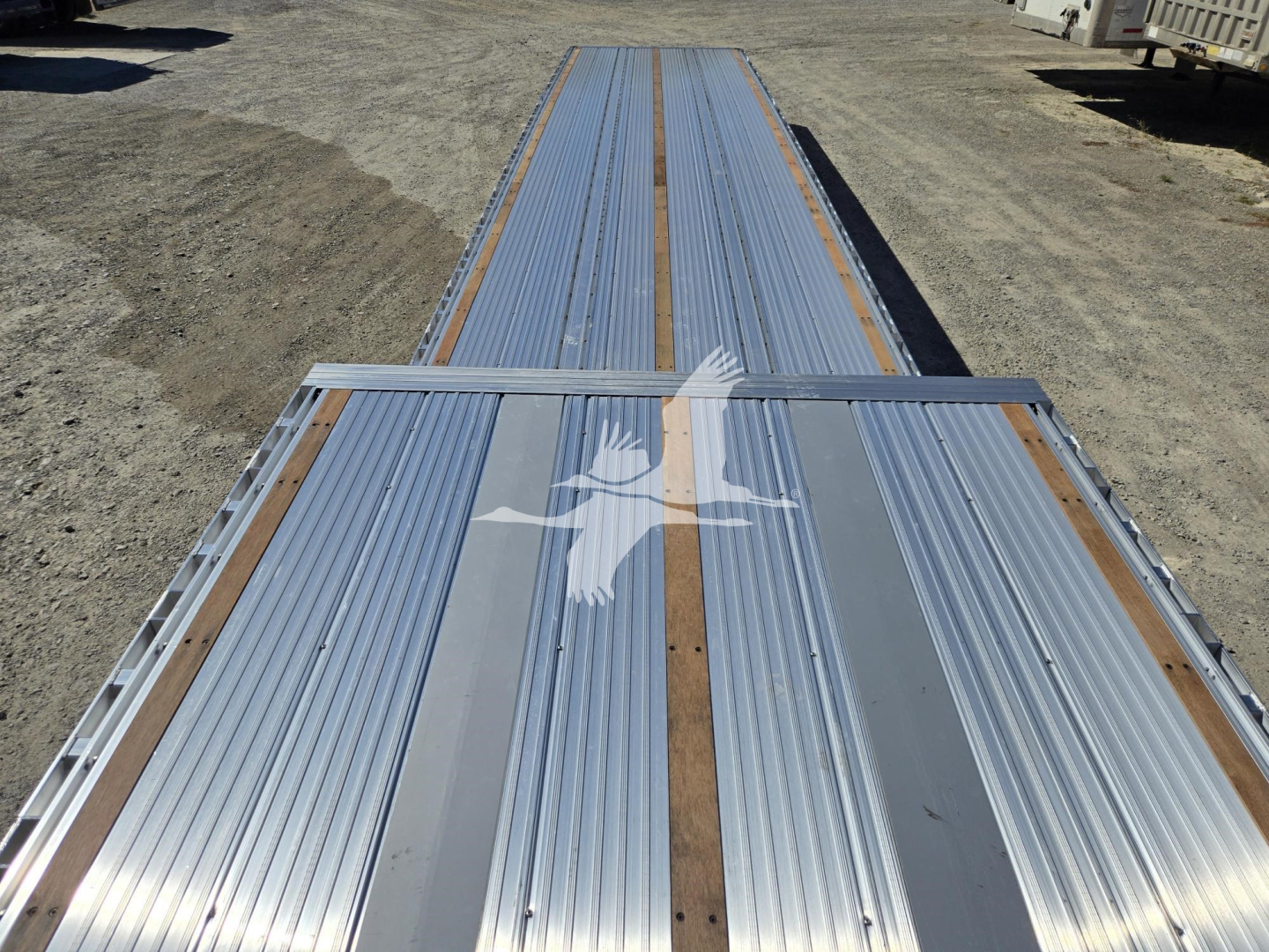 New Reitnouer Big Bubba Dropdeck trailer long aluminum deck with center beams and white bird logo at rear.