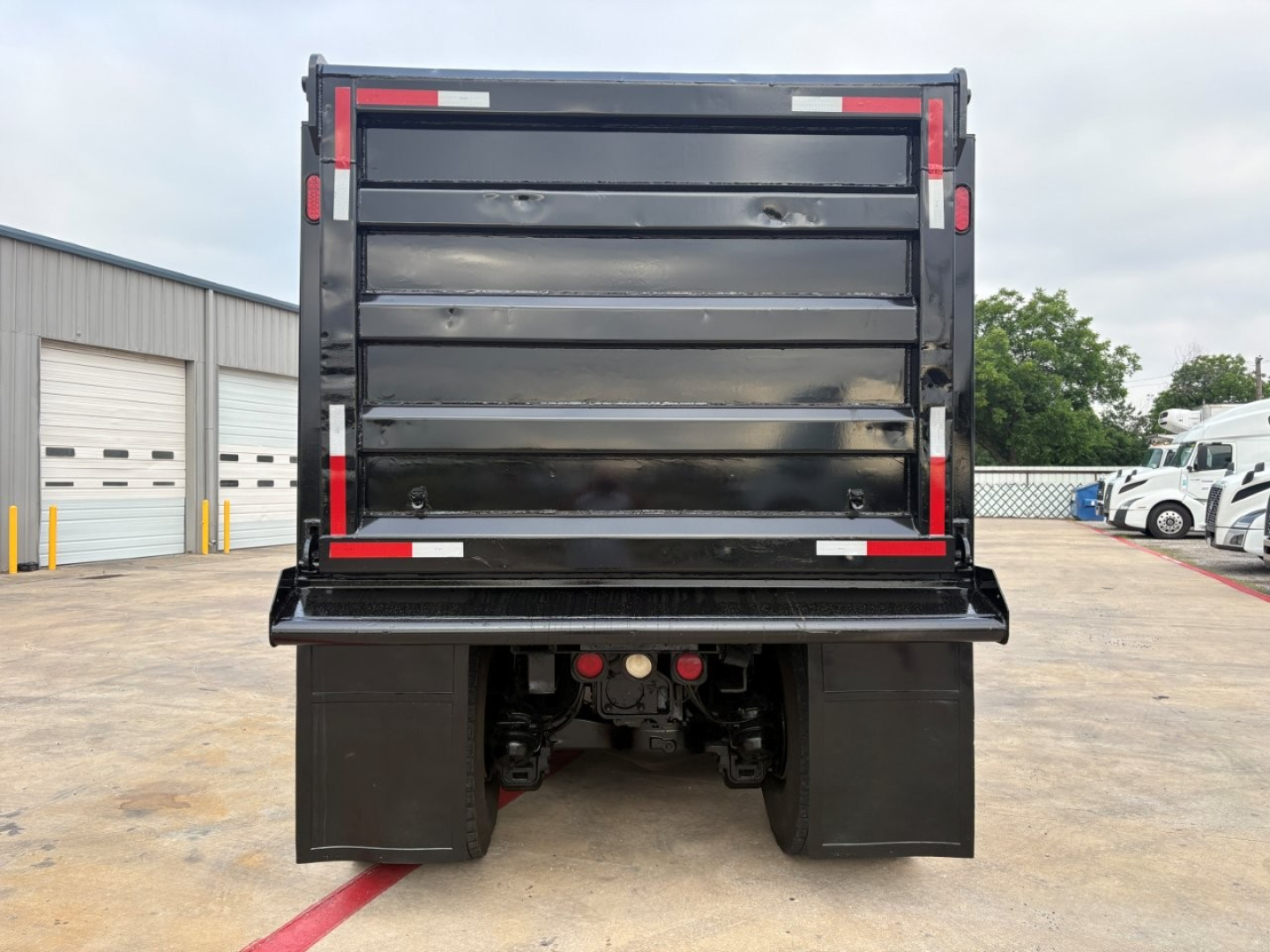 Dump truck bed of a 2020 Mack GR64F rear view showing dump bed and bumper details.