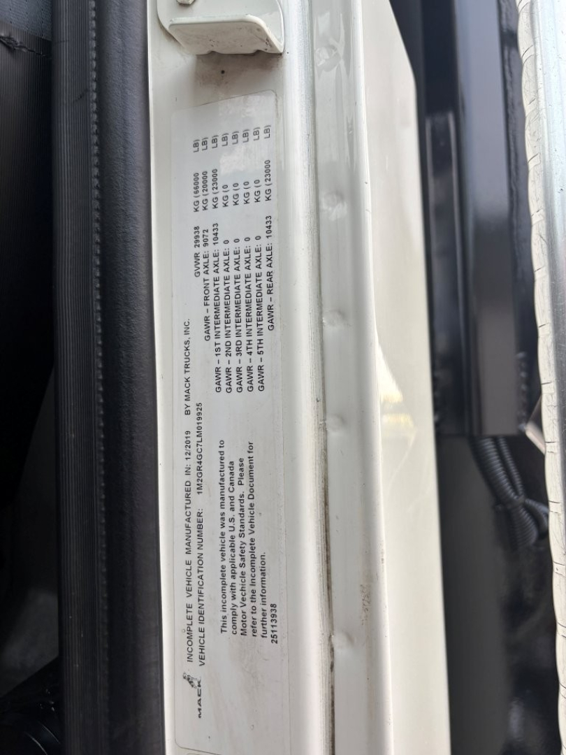 VIN sticker on Mack GR64F door frame showing vehicle details and warnings.