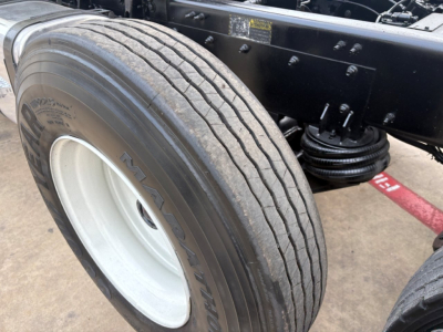 Mack GR64F dump truck front wheel showing tire sidewall and suspension components.