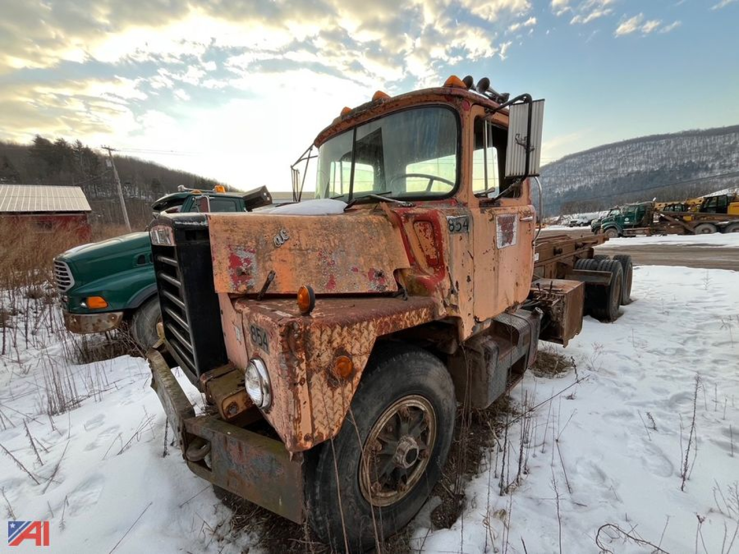 Tilt cab Mack truck with peeling paint and mud, front view showing worn wheel, side view of tilt frame truck in snow.