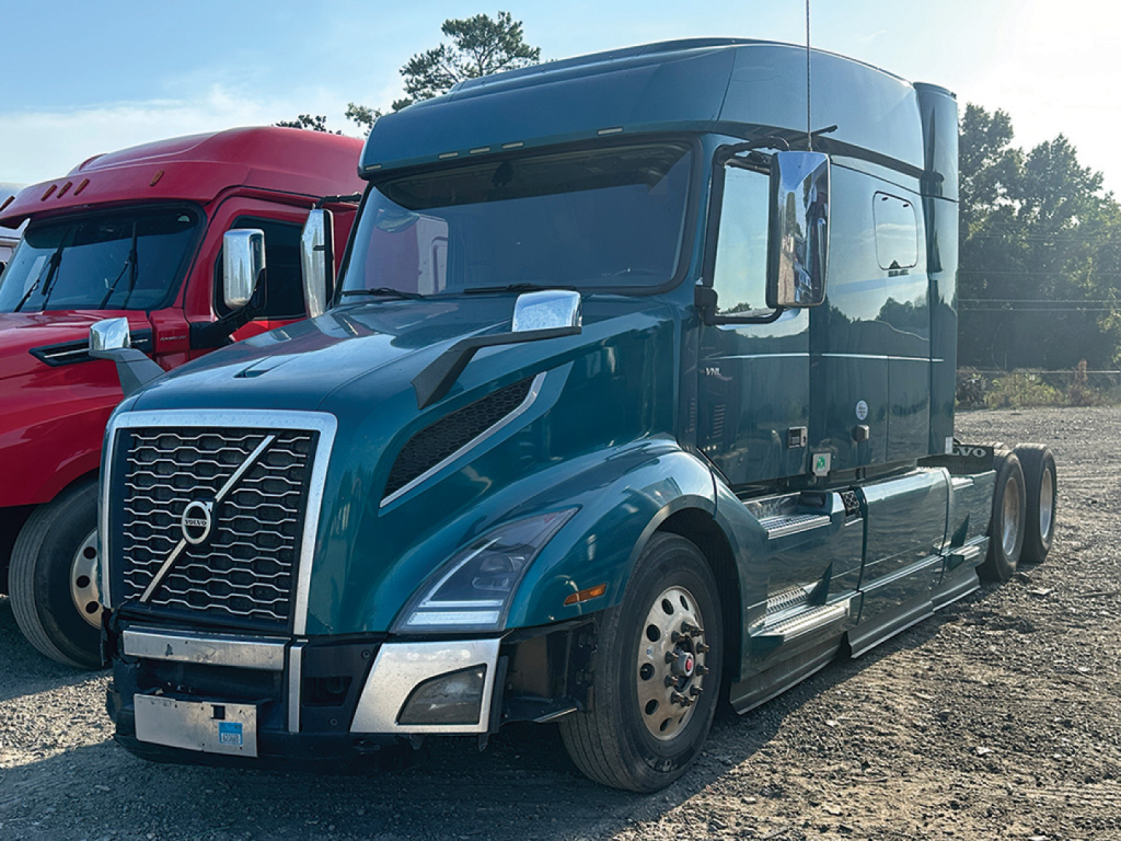 Volvo VNL 740 long haul truck in blue shown from front-right side with chrome grille and dual rear axles.