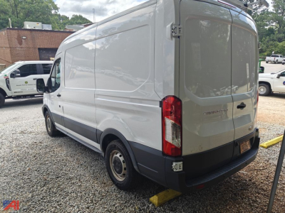 Ford Transit full-size van rear view showing cargo van with rear doors and badge, side paneling, and wheel wells.