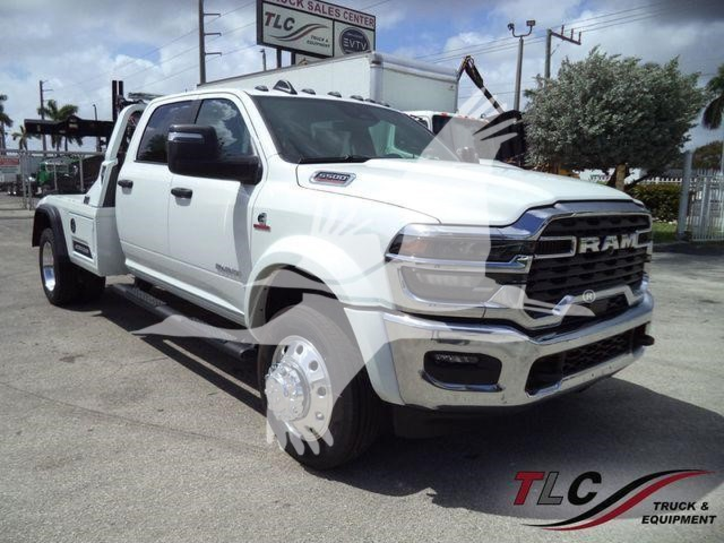 Ram 5500 pickup truck in white, front three-quarter view with winch; RAM grille, large tires, dual rear wheels; dealership lot in background.