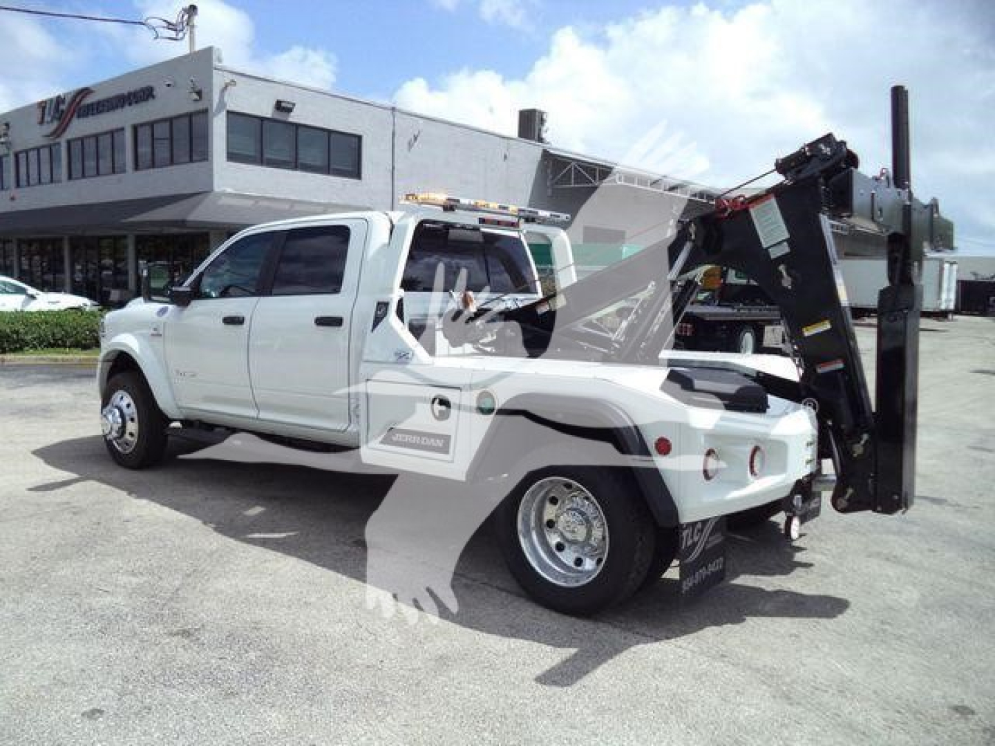 Ram 5500 Big Horn truck with a mounted hydraulic winch in rear bed, white crew cab, side view showing branding and winch equipment.