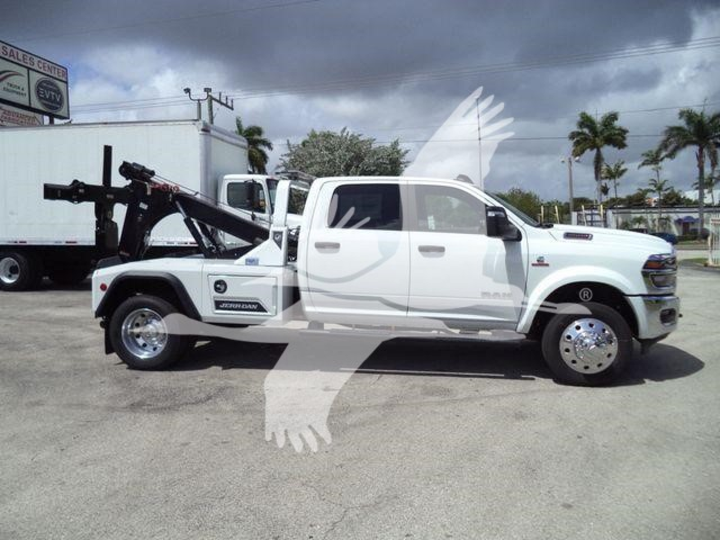 Ram 5500 tow truck side profile showing tow wrecker equipment mounted behind cab and chrome wheels