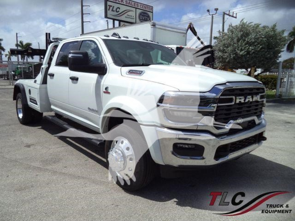 Ram 5500 pickup truck in white, front three-quarter view with winch; RAM grille, large tires, dual rear wheels; dealership lot in background.