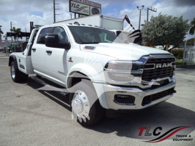 Ram 5500 pickup truck in white, front three-quarter view with winch; RAM grille, large tires, dual rear wheels; dealership lot in background.