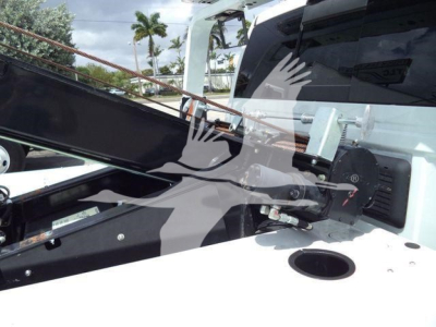 Ram 5500 pickup bed with winch system and hydraulic hose fittings visible; cab rear window and towing components in view.