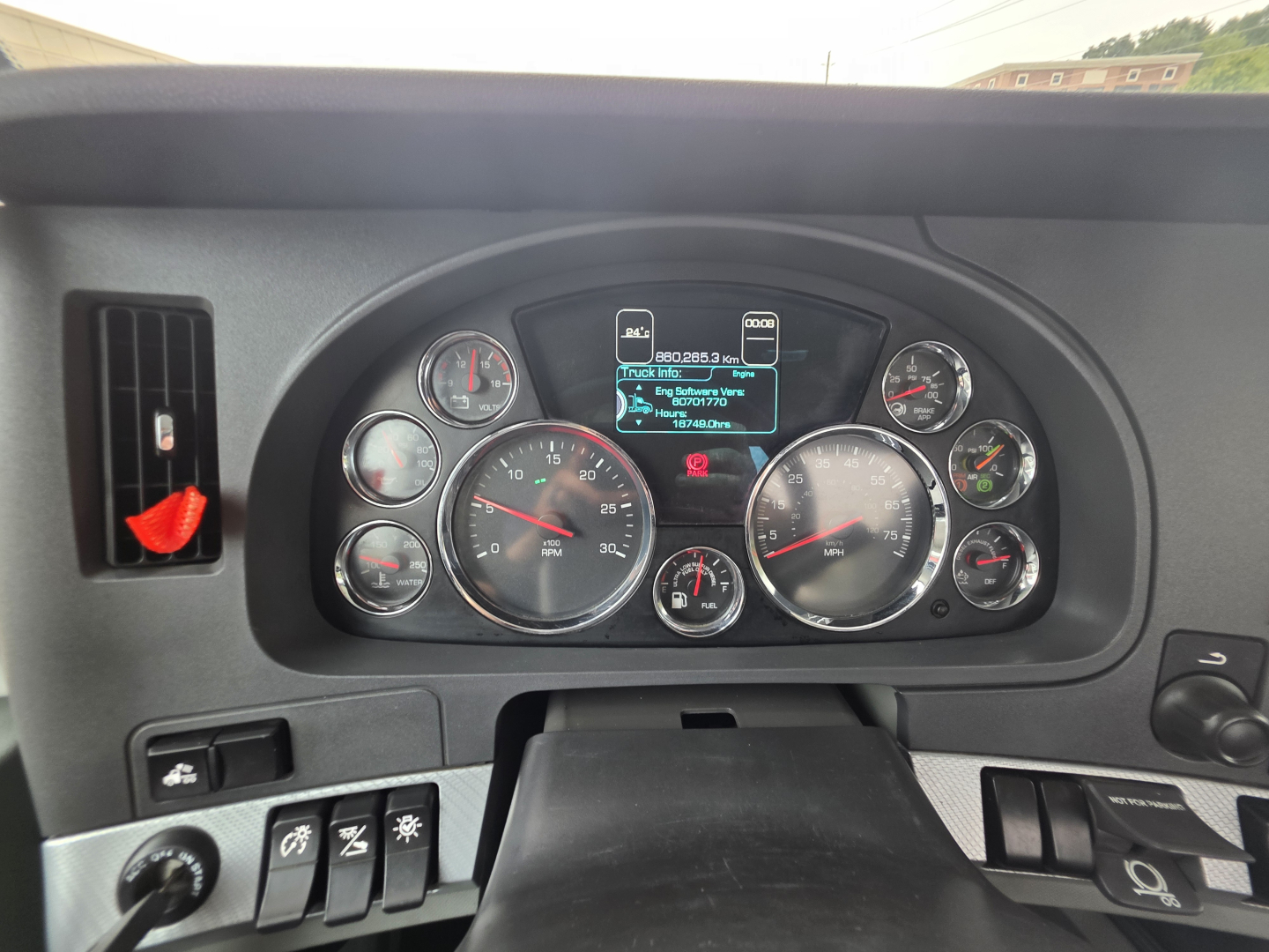 Dashboard view of a Kenworth T880 showing multiple gauges and a central digital display.