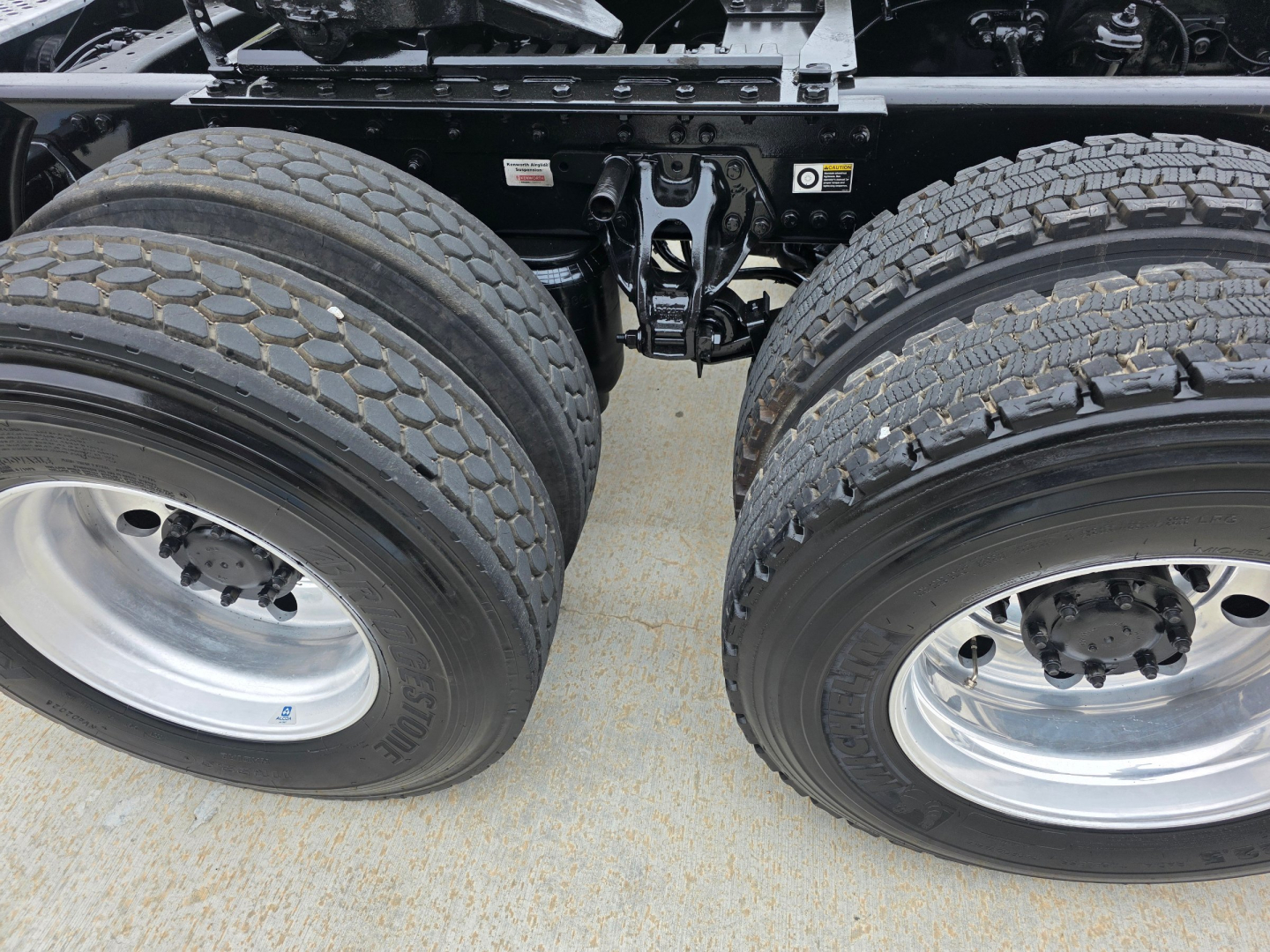 Dual rear axle tires of a Kenworth T880 tractor showing tandem wheels and suspension components.