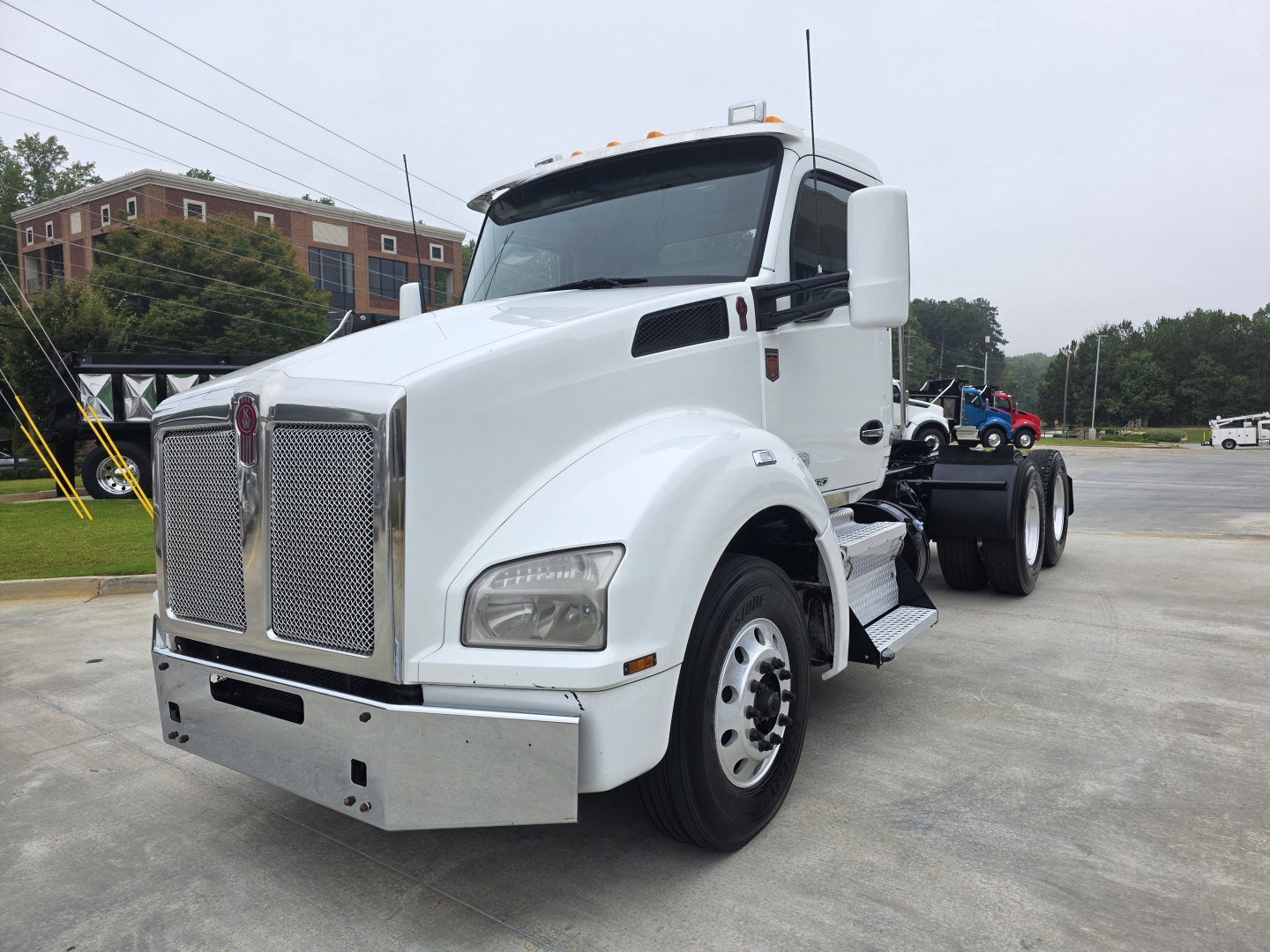 Kenworth T880 tractor in white, front-left view showing grille, headlights, bumper, and side steps; no text visible on components.