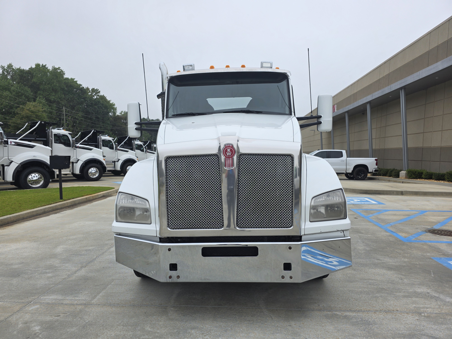 Kenworth T880 front view showing large grille, bumper, and cab in daylight.