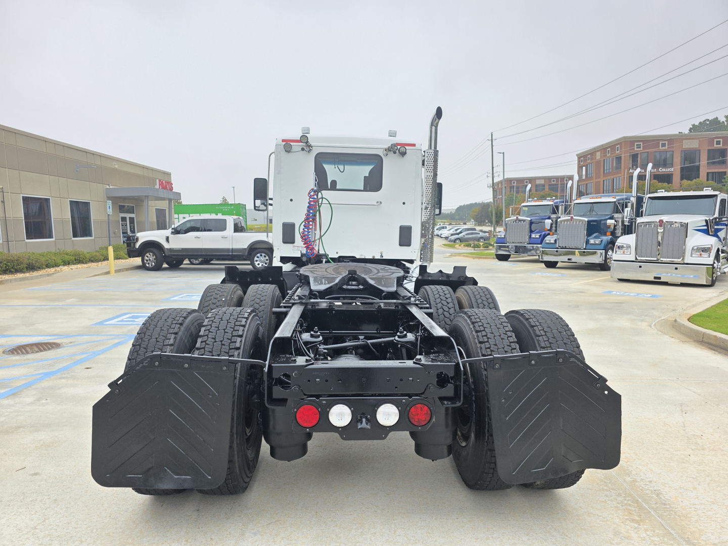 Kenworth truck rear view showing dual rear axles with large fenders and bumper lights. VIN and stock label not visible in this image.