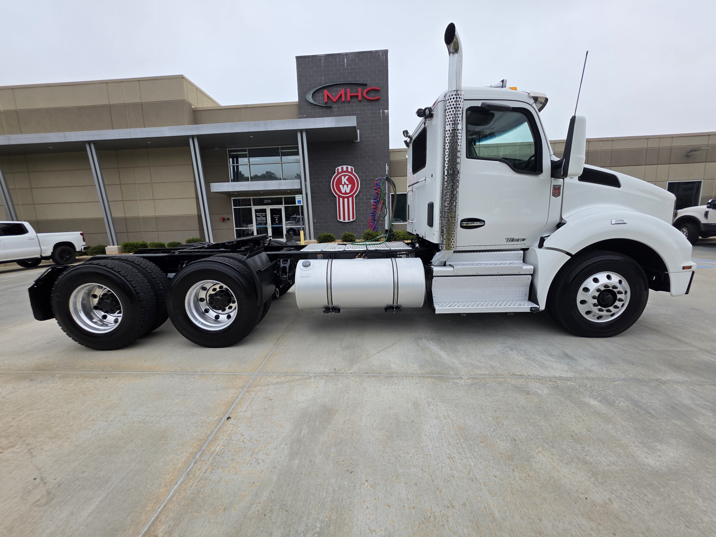 Kenworth T880 conventional daycab truck side view showing fuel tanks and tandem rear axles.