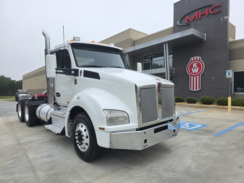 Kenworth T880 conventional daycab tractor in white, front grille and bumper visible, side view with dual rear axles and fuel tanks.