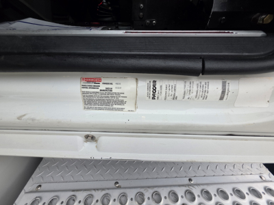 Label on door sill area of a Kenworth T880 showing compliance/weight and serial information with bar codes; sticker includes model and VIN context.