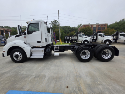 Kenworth T880 truck chassis side view showing cab and dual rear axles with white paint and chrome accents.