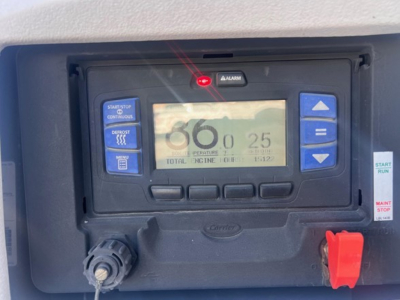 Reefer trailer control panel with digital display showing 68 and 25, buttons on sides, red emergency switch, and control dials.